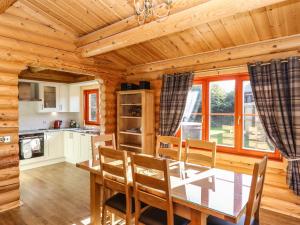 a dining room with a table and chairs in a cabin at Pine Lodge in Oakham