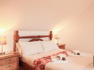 a bedroom with a bed with towels on it at Sweetheart Cottage in Dalbeattie