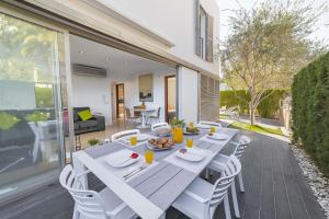 a wooden table with white chairs on a patio at Villa Salines House in Alcudia