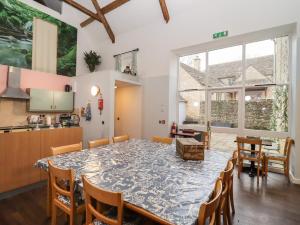 a dining room and kitchen with a table and chairs at Greyhound Barn in Ampney Crucis