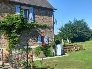 a stone house with a bench in front of it at Captivating 2-Bed Cottage in Mortain-Bocage in Notre-Dame-du-Touchet