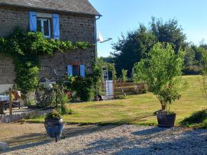 a house with two potted trees in front of it at Captivating 2-Bed Cottage in Mortain-Bocage in Notre-Dame-du-Touchet