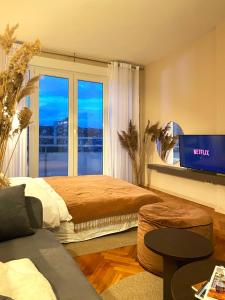 プリシュティナにあるEtern Stays - Zen Apartmentのベッドと大きな窓のある寝室