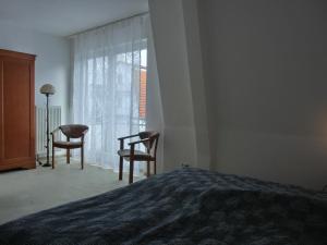 - une chambre avec un lit, deux chaises et une fenêtre dans l'établissement Ferienwohnung A3, à Graal-Müritz