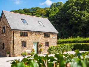 a stone house with a green door in a garden at Brightley Mill Barn in Okehampton