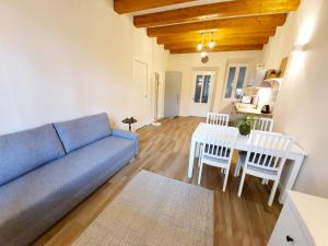 Una sala de estar con un sofá, una mesa y sillas. en RESIDENZA LA RUGA Matilde & Eleonora Apartments Lake, en Verbania