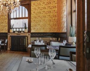 a restaurant with tables and chairs and a chandelier at Clementine in Kruishoutem