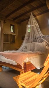 um quarto com uma cama e uma rede mosquiteira em Lo De Ro em Barra de Valizas
