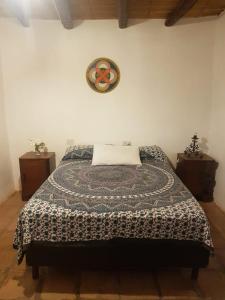 a bedroom with a bed and a clock on the wall at Casa Prana Estudio de Yoga in Cafayate