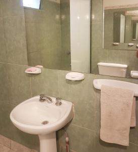 een badkamer met een wastafel, een toilet en een spiegel bij Casa Prana Estudio de Yoga in Cafayate