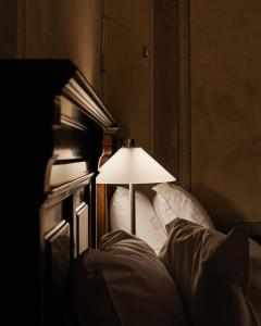 a dimly lit room with a bed and a lamp at Hotel Copernicus in Krakow