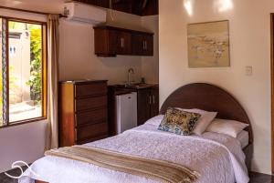 1 dormitorio con 1 cama y cocina en Tranquilidad Resort, en Parrita