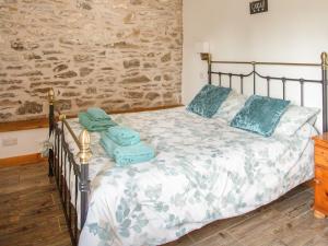 a bedroom with a bed with blue pillows on it at 2 Beacon View Barn in Felindre