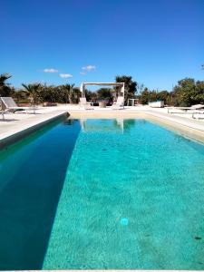 een zwembad met turquoise blauw water bij Le Casette fra le Masserie in Fasano