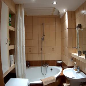 ein Badezimmer mit einer Badewanne und einem Waschbecken in der Unterkunft Apartament Hetmańska in Wałbrzych