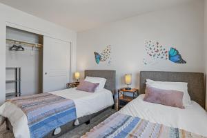 a bedroom with two beds and butterflies on the wall at Bliss Flagstaff 49 townhouse in Bellemont