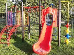 a playground with a colorful slide on the grass at Gulpdal Vakantiewoningen. in Gulpen