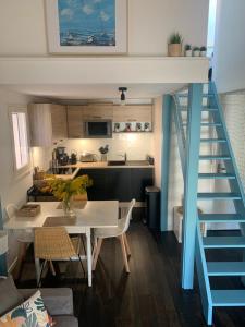 eine Küche und ein Esszimmer mit einer Treppe in einem winzigen Haus in der Unterkunft Maison vacances résidence privée Piscine Loupian-Mèze in Loupian