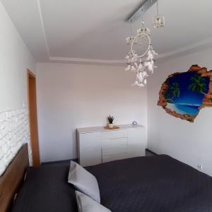 a bedroom with a bed and a chandelier at Apartament Hetmańska in Wałbrzych
