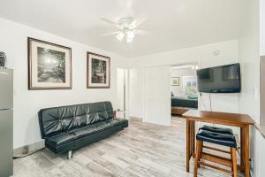 a living room with a black leather couch and a table at SII 1 Bedroom Tropical GEM! in West Palm Beach