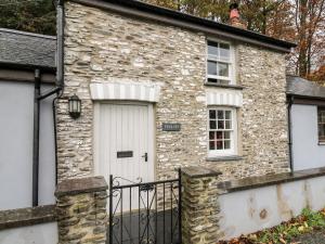 a stone house with a white door and windows at Penlon in Aberystwyth