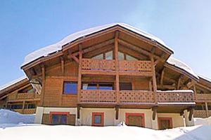a large wooden building with a snow covered roof at Luxury Family Ski Chalet - Jacuzzi BBQ - Near Lake Golf - Multipass access 60 Summer activities - Sleep 10 in Les Gets +36 photos