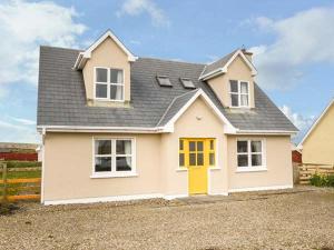 a large white house with a yellow door at Bonnie Doon in Kilfearagh