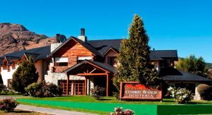 a log home with a sign in front of it at Hostería Cumbres Blancas in Esquel