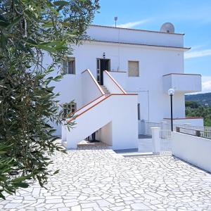Biały dom ze schodami przed nim w obiekcie Residence Arcobaleno w mieście Peschici