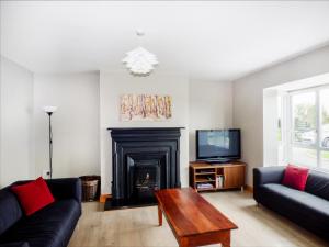 sala de estar con chimenea y TV en Elrove, en Nelson Bridge