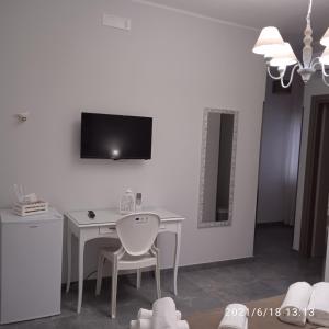 a white desk with a chair and a television on a wall at Residence Arcobaleno in Peschici