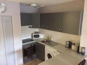 a kitchen with a sink and a microwave at One Bedroom Apartment - Los Cristianos in El Guincho