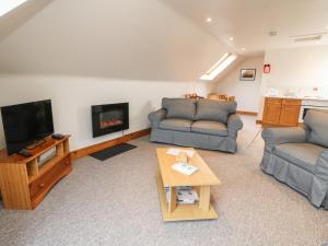 ein Wohnzimmer mit 2 Sofas und einem TV in der Unterkunft Stewart in Pitlochry