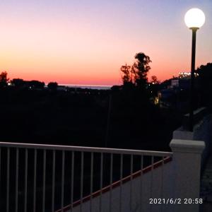 einen Sonnenuntergang über dem Meer mit Straßenbeleuchtung in der Unterkunft Residence Arcobaleno in Peschici