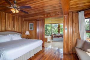 a bedroom with a bed and a bathroom with a tub at Hotel Belmar in Monteverde Costa Rica