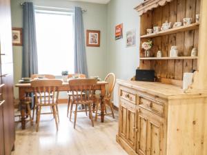a kitchen and dining room with a table and chairs at The Oaks Cottage in Penrith