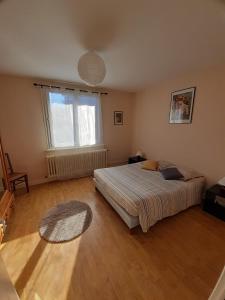 a bedroom with a bed and a large window at Le Nid des Avezous in Avèze