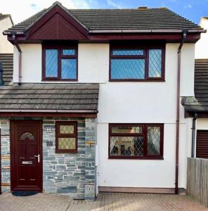 a white house with a brown door and windows at 44 Raleigh Close@Padstow in Padstow