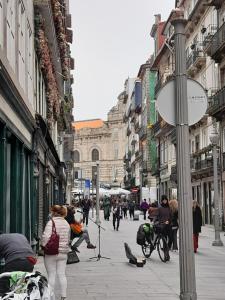 a group of people walking down a city street at Great&Cosy São Bento in Porto