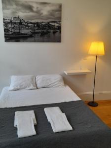 a bedroom with a bed with two towels on it at Great&Cosy São Bento in Porto