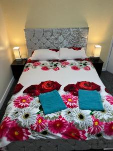 Una cama con flores rojas y blancas. en Blackpool Beach Holiday Flats, en Blackpool
