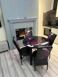 a dining room with a table and chairs and a fireplace at Blackpool Beach Holiday Flats in Blackpool