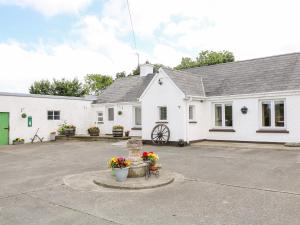 una casa blanca con una fuente frente a ella en Whispering Willows - The Bungalow, en Craigtown