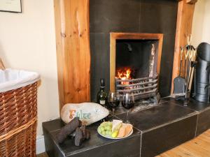 una mesa con un plato de comida y una chimenea en Whispering Willows - The Bungalow, en Craigtown