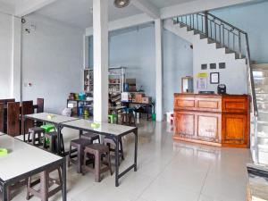 a room with tables and chairs and a staircase at OYO 90922 Gurusinga Guesthouse in Medan