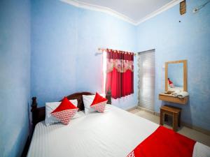 Un pat sau paturi într-o cameră la OYO 90922 Gurusinga Guesthouse