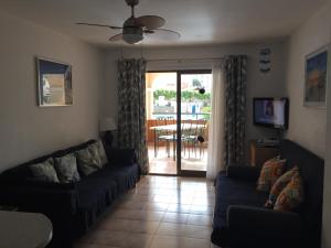 a living room with two couches and a sliding glass door at One Bedroom Apartment - Los Cristianos in El Guincho
