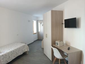 a bedroom with a bed and a desk with a chair at Gufo Depandance in Bormio