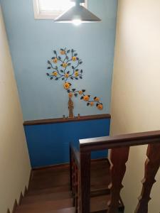a stairway with a blue wall with a flower mural at Casa da Kau in Ouro Preto