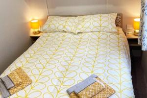 a bedroom with a bed with a yellow and white comforter at Lido leisure park in Knaresborough